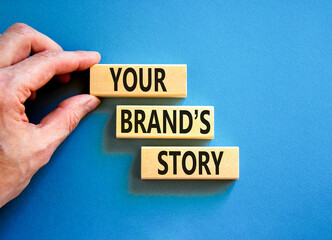 Branding and your brand story symbol. Concept words Your brands story on beautiful wooden blocks. Beautiful blue background. Businessman hand. Business branding your brand story concept. Copy space.