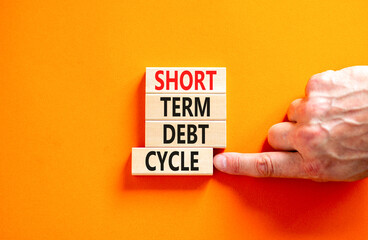 Short term debt cycle symbol. Concept words Short term debt cycle on beautiful wooden block. Beautiful orange table background. Businessman hand. Business Short term debt cycle concept. Copy space.