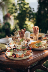 Food, a beautifully decorated catering banquet table with a variety of appetizers with cheese, ham, prosciutto and fruit. At a corporate, Christmas, birthday or wedding celebration. Buffet table. Buff
