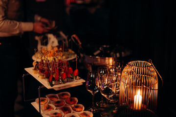 Food, a beautifully decorated catering banquet table with a variety of appetizers with cheese, ham, prosciutto and fruit. At a corporate, Christmas, birthday or wedding celebration. Buffet table. Buff