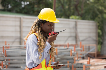 African American female engineer control work by radio communication at construction site