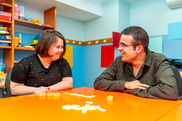 Woman with down syndrome and disabled man playing board games