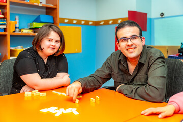 Two people with special needs distracted playing board games