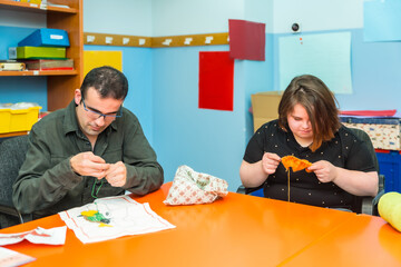 People with intellectual disabilities knitting clothes with wool