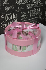 Zephyr in a box. Marshmallow tulips. The box is pink, tied with a ribbon. It stands on a white...