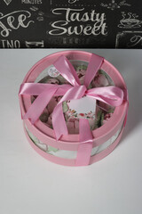 Zephyr in a box. Marshmallow tulips. The box is pink, tied with a ribbon. It stands on a white table