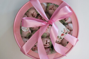 Zephyr in a box. Marshmallow tulips. The box is pink, tied with a ribbon. Close-up. View from above.