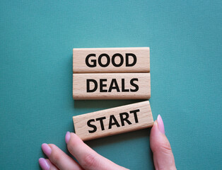 Good Deals Start symbol. Concept words Good Deals Start on wooden blocks. Businessman hand. Beautiful grey green background. Business concept. Copy space.