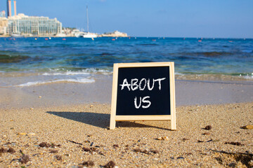 About us symbol. Concept word About us on black chalk background. Beautiful sea background....