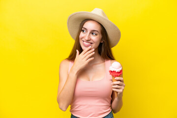 Young caucasian with a cornet ice cream isolated on yellow background looking up while smiling