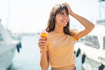 Young woman with a cornet ice cream at outdoors has realized something and intending the solution