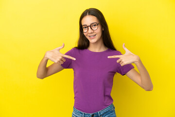 Young French woman isolated on yellow background proud and self-satisfied