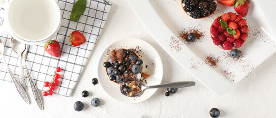 Tasty berry tartlets on light background, top view