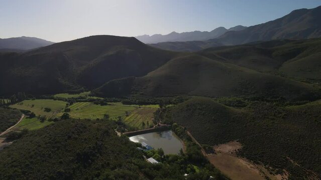 Fly over across the beautiful De Cango South African green landscape with the farms 