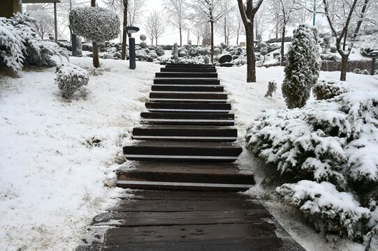 Wooden steps in a winter park after fresh snowfall