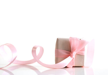 Small present box with bow on white background. Gift decorated with pink ribbon empty copy space.