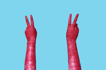 Woman with painted hands showing victory gesture on color background, closeup