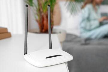 Modern wi-fi router on table in bedroom, closeup