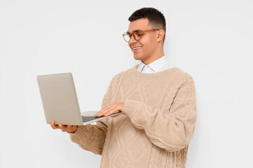 Male author using laptop on light background