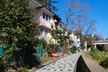street in the town. Travel concept. Poor area with small pink houses in a southern town, idyllic view on a sunny day, against a backdrop of greenery and blue sky.