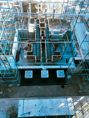A construction site with scaffolding and a blue sky in the background. The construction site is in the process of building a structure