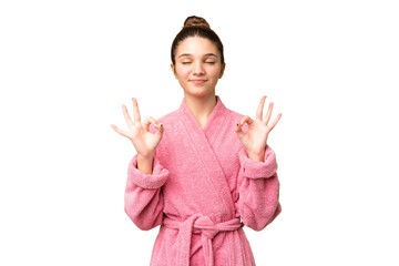 Teenager girl in a bathrobe over isolated chroma key background in zen pose