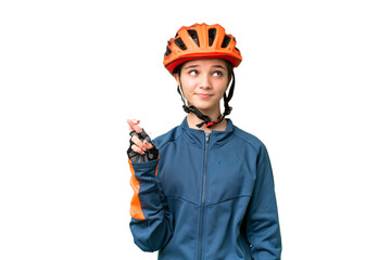 Teenager cyclist girl over isolated chroma key background with fingers crossing and wishing the best