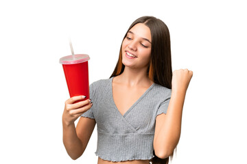 Teenager caucasian girl holding a soda over isolated background celebrating a victory