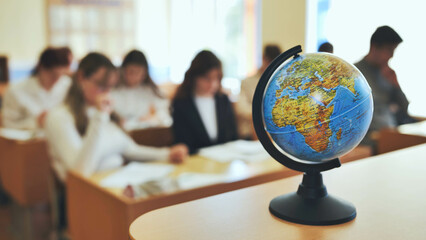 A globe of the world in a school classroom during a lesson. The globe shows Africa and Eurasia.