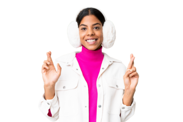 Young African American woman wearing winter muffs over isolated chroma key background with fingers crossing