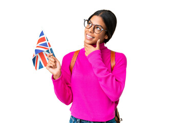 Young African American woman holding an United Kingdom flag over isolated chroma key background thinking an idea while looking up