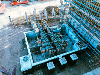 A construction site with scaffolding and a blue sky in the background. The construction site is in the process of building a structure