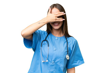 Young nurse caucasian woman over isolated background covering eyes by hands and smiling