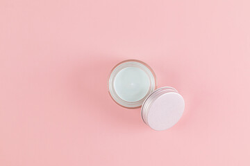 cosmetic jar with natural self-care cream on pink background. Top view. A copy space. Natural...