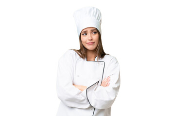 Young chef caucasian woman over isolated background making doubts gesture while lifting the shoulders