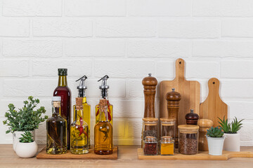 Stylish kitchen background with a set of bottles with various cooking oils, glass jars with spices,...