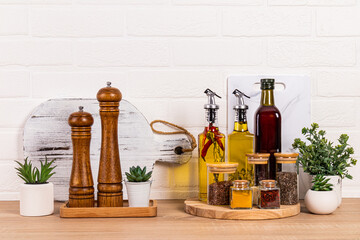 Lots of different kitchen utensils, oil bottles, spice mill and potted plants. A modern look of the...