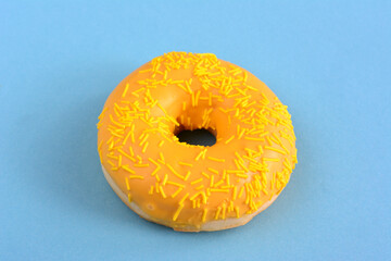 yellow lemon donut isolated on blue background close up