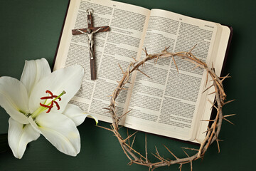 A symbolic Christian composition with Holy Bible lies beside a crown of thorns and a fresh white...