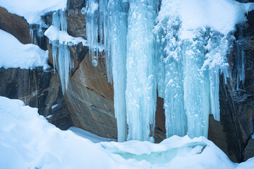 Huge blue-colored icicles on a rock wall