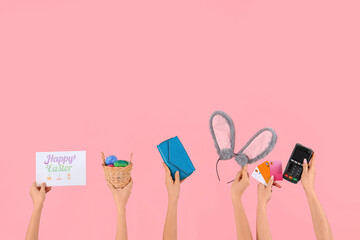 Women with Easter decor, credit cards, wallet and payment terminal on pink background. Online shopping