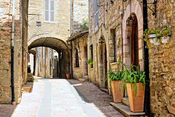 Beautiful street in the medieval old town of Assisi, with covered walkway, Umbria, Italy