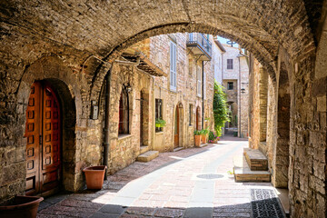 Beautiful arched street in the medieval old town of Assisi, Umbria, Italy