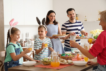 Happy family having Easter dinner in kitchen