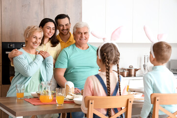 Happy family hugging at Easter dinner in kitchen