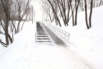 Stairs and ramp with metal railings for the passage of strollers and wheelchairs in public park at...