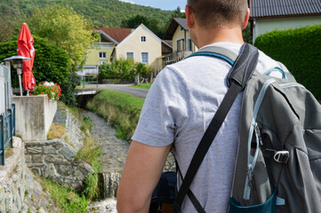 Unrecognizable man enjoins with travel and walking in Austrian village.