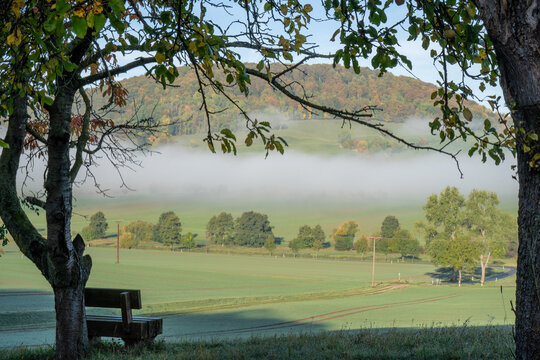 Morgenstimmung im Eichsfeld. Nebel liegt auf den Feldern. Eine Bank l&auml;dt zum verweilen ein mit Blick zur Hasenburg.
