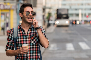 Close up portrait of cheerful mature man using mobile phone and laughing. Handsome hipster talking...