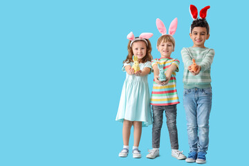 Cute little children in bunny ears with toys rabbit on blue background. Easter celebration